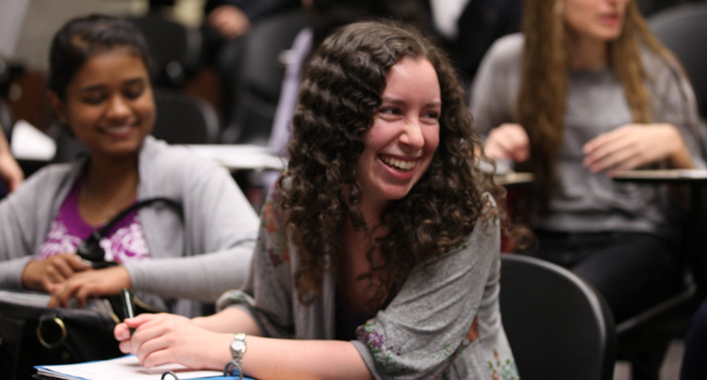 CCNY students in lecture hall smiling 