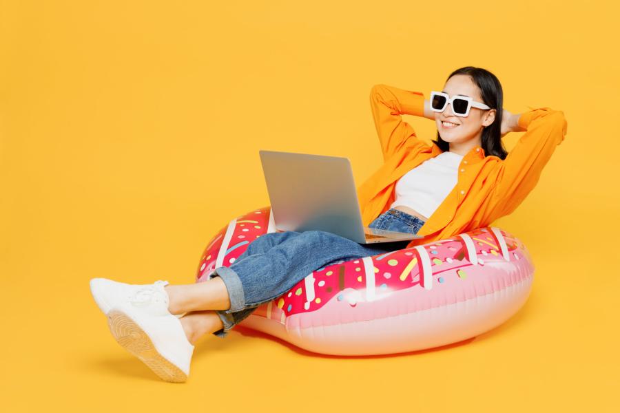 Woman sunbathing with laptop on lap