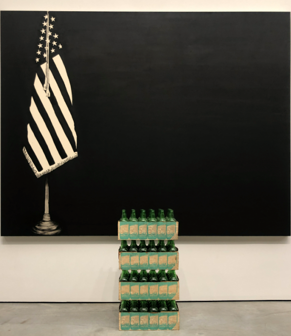 Harlem Art Gallery shows an American flag and carton of bottles.