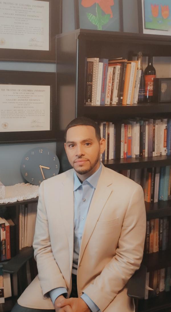 Dr. Thompson sitting in front of o book shelf