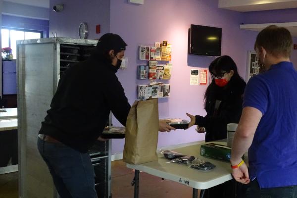 Personal Touch employee (left) distributes meal to Towers resident.